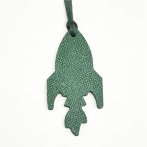 Dettaglio ciondolo borsa razzo in pelle verde, elegante portachiavi e accessorio borsa.