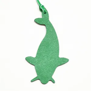 Detalle de dije de bolso de ballena de cuero verde, colgante de animal texturizado para bolsos.