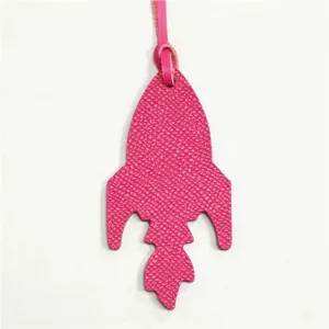 Dettaglio charm borsa in pelle a razzo rosa, elegante ciondolo e accessorio grazioso.