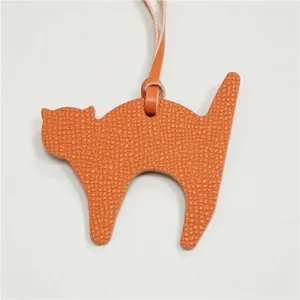 Orange leather cat bag charm pendant for women handbags, cute animal keychain accessory.