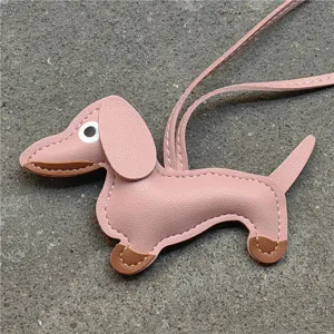 Détail de pendentif sac teckel en cuir rose, charm accessoire pour chiot mignon.