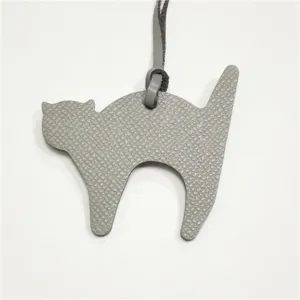 Detailed view of grey leather cat bag charm, textured leather pendant for women handbag accessory