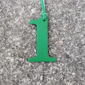 Green leather number 1 bag charm, DIY accessory detail shot, lucky number pendant decor.