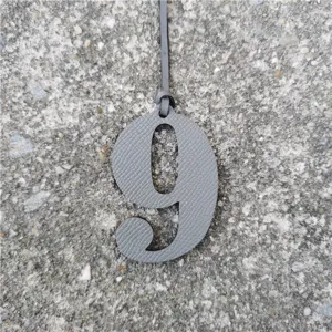 Grey leather number 9 bag charm detailed view, perfect for DIY purses and handbag decoration.