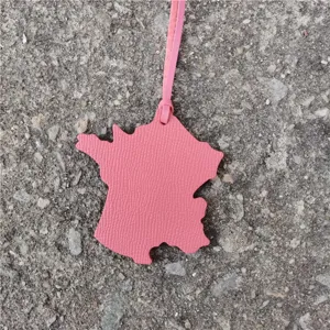 Pink leather France map bag charm and car hanging ornament detail view showing shape and texture.