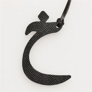 Detail view of black leather Arabic letter bag charm and exquisite keychain pendant.