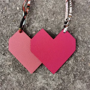 Heart shaped leather bag charm with silk ribbon strap, elegant accessory for women's handbag.
