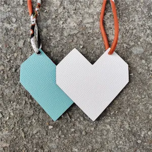 Heart-shaped leather bag charm dual-tone pendant with orange strap detail for women accessory