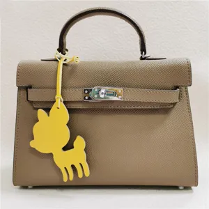 Elegant taupe women handbag featuring a cute yellow deer leather charm, premium daily bag.