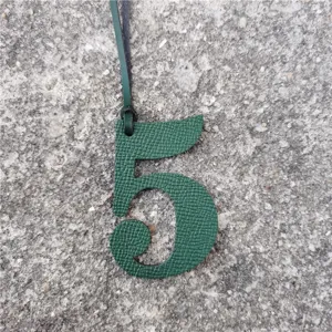 Pendentif de sac numéro 5 en cuir vert vue de détail accessoire porte-bonheur DIY