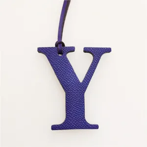 Detail shot of purple leather letter Y bag charm, initial charm accessory for handbags.