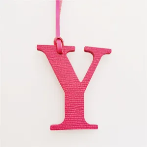 Detailed close-up of the pink leather letter Y charm, showing fine texture and strap.
