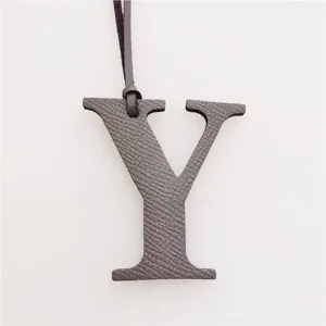 Detail view of the leather letter Y bag charm, featuring textured initial pendant with strap.