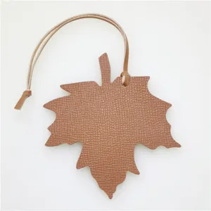 Brown leather maple leaf bag charm and stylish car interior hanging pendant with leather strap.