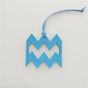 Aquarius blue leather zodiac charm with hanging strap, chic astrology design accessory for bags.