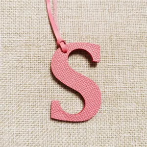 Rosa Leder Buchstabe S Taschenanhänger Detailansicht, feine Textur und passender Riemen ideal.