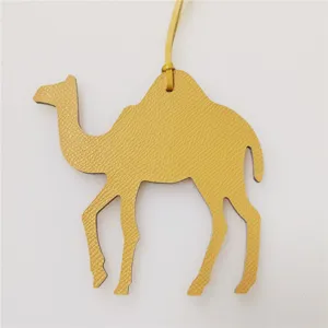 Detailed close-up of a yellow leather camel bag charm, stylish purse accessory pendant.