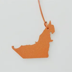 Close-up detail view of the UAE map shaped leather bag charm pendant, elegant texture.