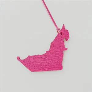 Detailed close-up of the pink leather UAE map bag charm, showing fine grain texture and strap.