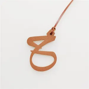 Ciondolo per borsa con lettera araba in pelle, elegante accessorio decorativo.