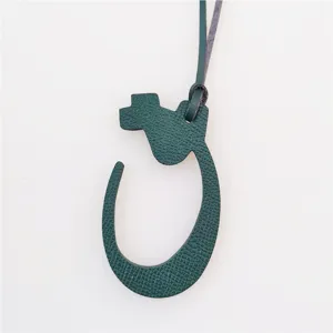 Dark green leather Arabic letter bag charm, stylish accessory for handbags and purses.