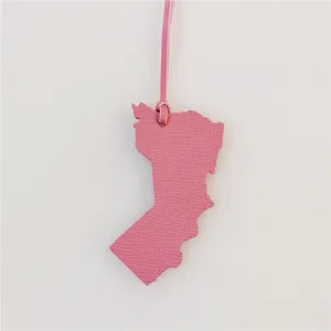 Pink leather Oman map shape bag charm detailed view showing fine texture and leather strap.