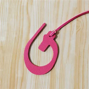 Vue détaillée du charm de sac en cuir rose avec une texture fine et une belle finition soignée.