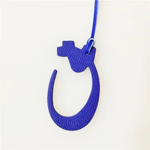 Blue leather Arabic letter bag charm pendant stylish accessory for handbags and backpacks.