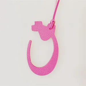Pink leather Arabic letter bag charm detail, stylish handbag pendant accessory for women.