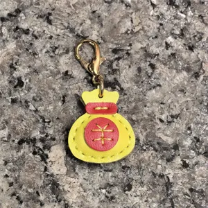 Llavero de la bolsa de la suerte de cuero genuino hecho a mano en amarillo y rojo.