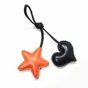 Bijou de sac en cuir fait main avec pendentif étoile orange et cœur noir élégant pour femmes.