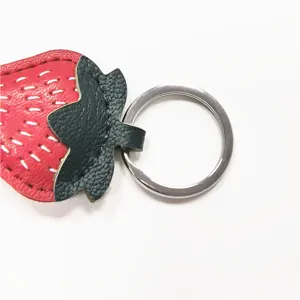 Cute strawberry leather keychain bag charm with metal ring and white stitching details.