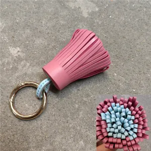 Rosa blaue Leder Quasten Taschenanhänger mit goldem Metallring, Detailansicht von unten.