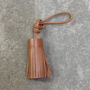 Genuine leather tassel charm detail shot, brown leather fringe keychain and bag pendant.