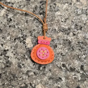 Detailed view of handmade leather lucky bag pendant, candy color keychain and bag charm.