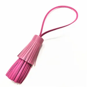 Nahaufnahme des doppelten rosa Lederquasten-Anhängers mit feiner Textur und praktischer Schlaufe.