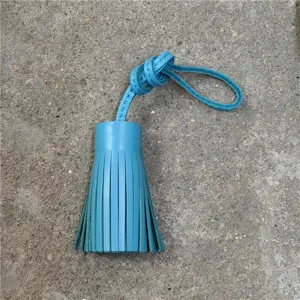 Blue leather tassel bag charm detail, handmade sheepskin car mirror hanging accessory.