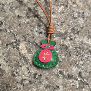Handcrafted genuine leather lucky bag pendant detail showcasing colorful stitching and cord.