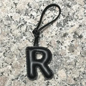 Black leather letter R bag charm detail, premium sheepskin initial pendant for purses and keys.