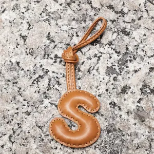 Light brown lambskin letter S bag charm, leather initial keychain and stylish car pendant accessory.