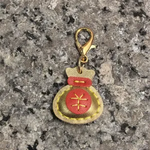 Colgante de bolsa de la suerte de cuero hecho a mano con mosquetón dorado y costuras de color.