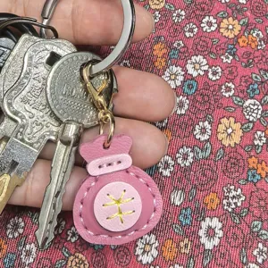 Detalle de llavero de bolsa de la suerte de cuero hecho a mano, dije rosa para llaves.