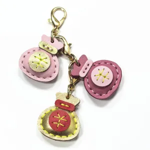 Llavero y colgante de bolso de cuero genuino hecho a mano con diseño de bolsa de la suerte.
