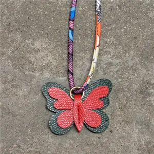 Mini dije de bolso de mariposa de cuero con accesorio de cuerda de bufanda de seda twilly de color.