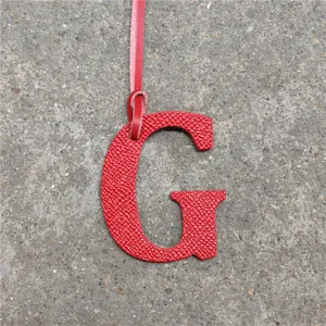 Red leather letter G bag charm accessory, stylish monogram initial pendant for handbags.