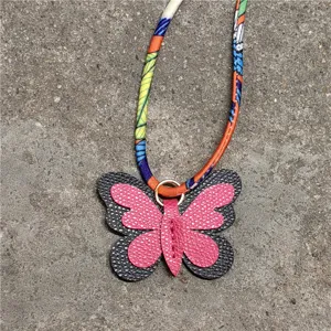 Mini colgante de bolso mariposa de piel con correa de panuelo de seda estampada color.