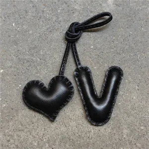 Colgante de bolso de cuero negro hecho a mano corazón y letra V vista detallada