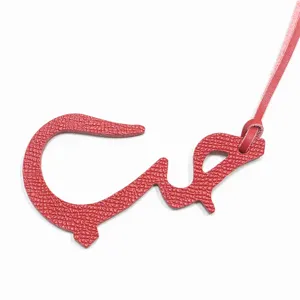 Détail de pendentif de sac en cuir véritable rouge lettre arabe belle texture.