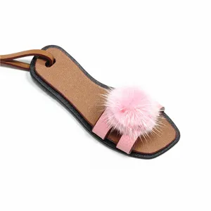 Mini Leder Hausschuh Tasche Anhänger mit flauschigem rosa Nerzpelzball und braunem Riemen.