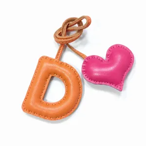 Handmade leather letter D and heart bag charm, stylish purse pendant and keychain accessory.